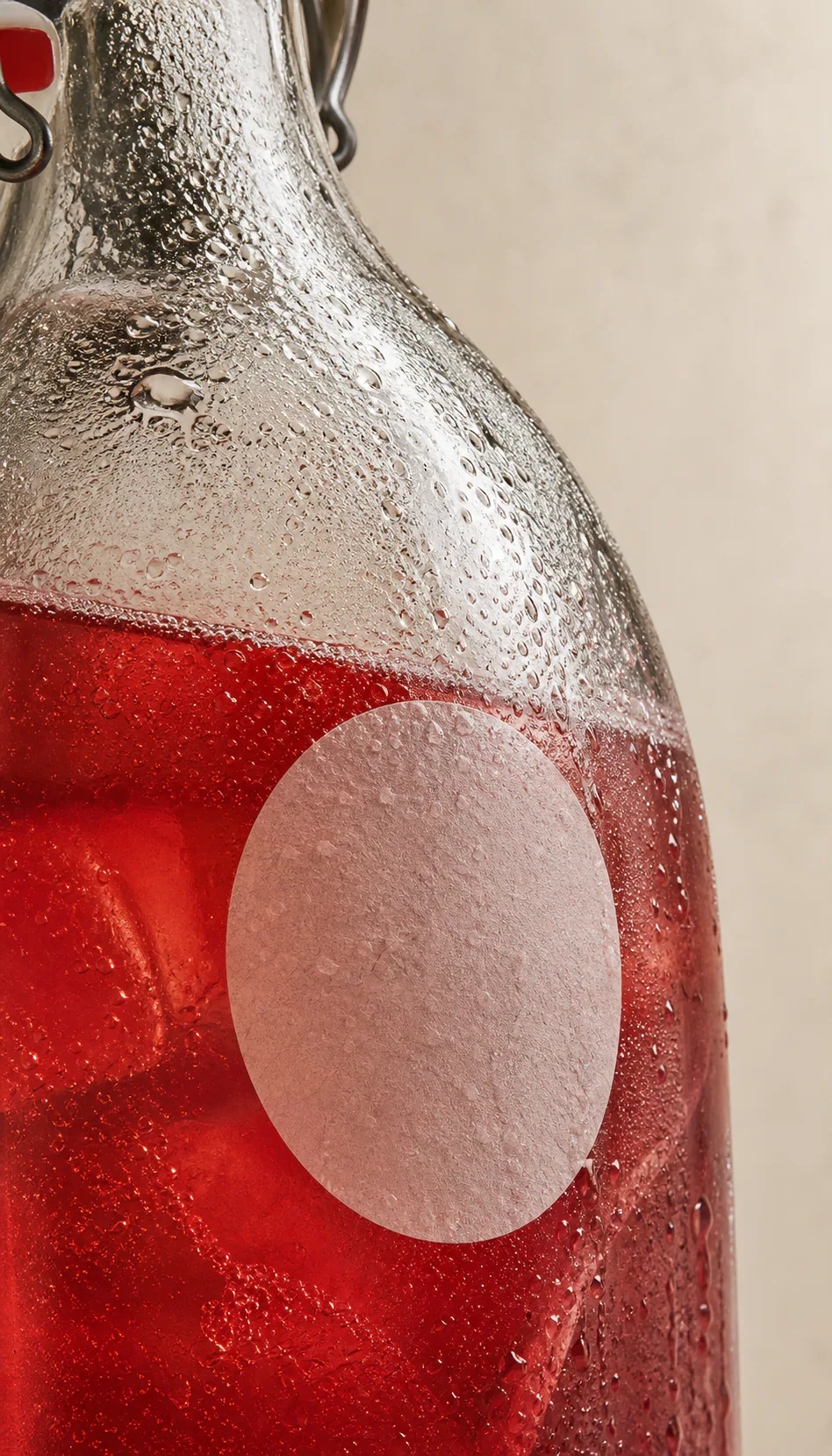 Condensation-covered bottle of ruby botanical soda