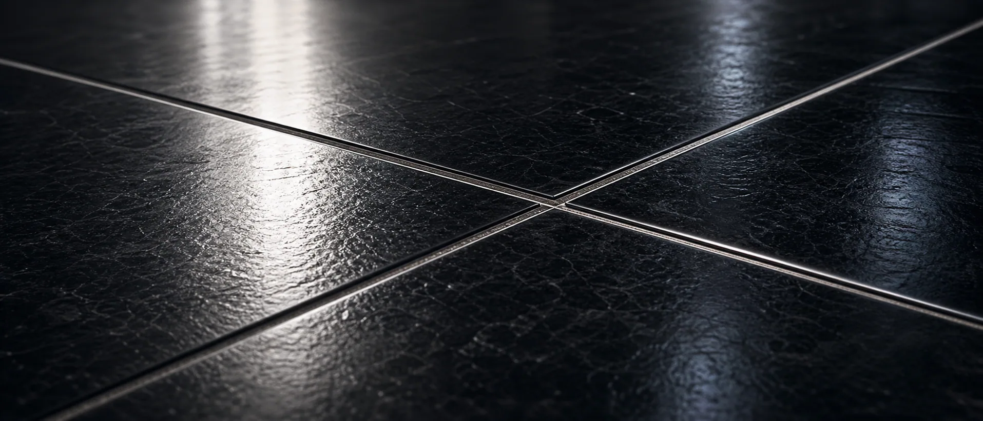 Close view of finished black tile with crisp crossing grout lines