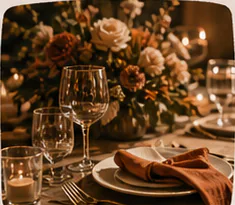 Dinner place setting with flowers, candlelight, and folded linen