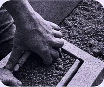 Hands working soil in a landscape garden