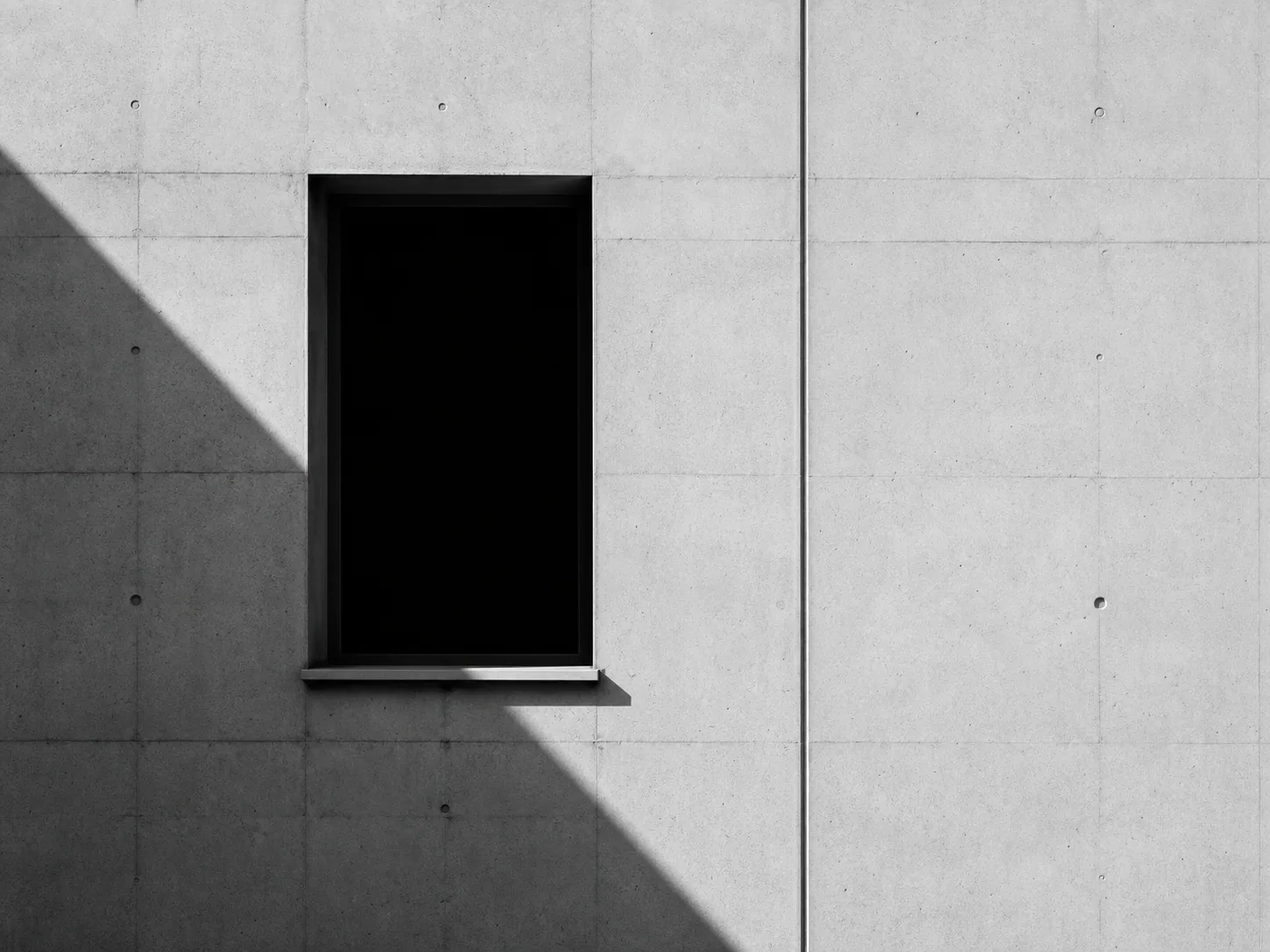 Concrete facade with one dark rectangular window