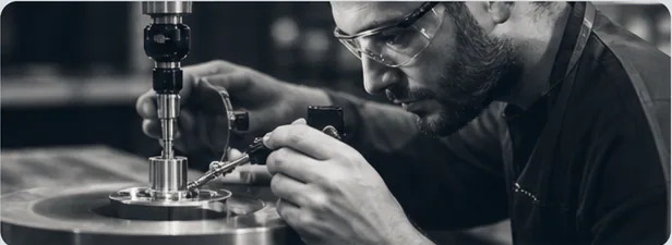 Technician inspecting a machined component with precision equipment