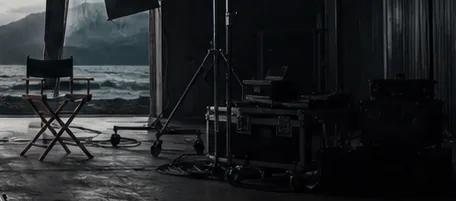 A concrete building beside a dark mountain lake