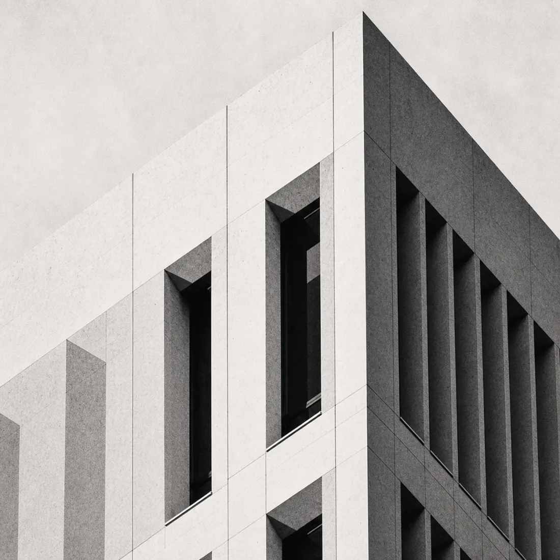 Monumental concrete facade with deep vertical window bays