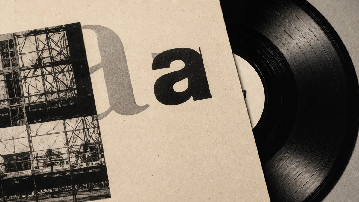 Vinyl record and printed sleeve beside a construction photograph