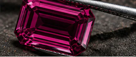 Faceted magenta gemstone held in a tool