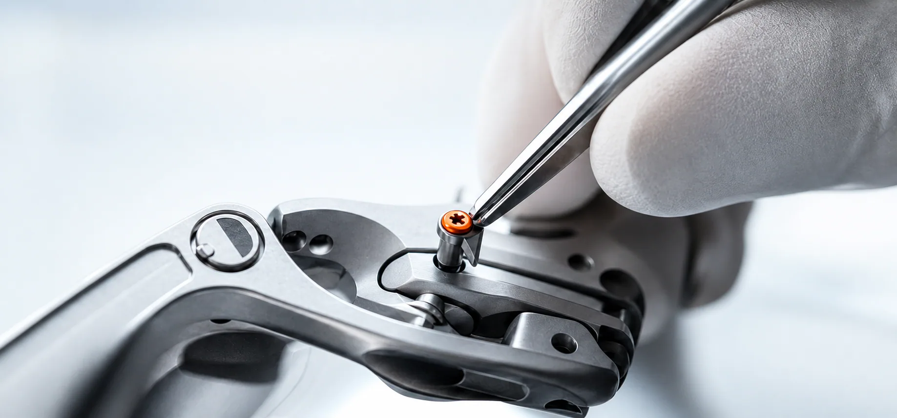 Gloved clinician assembling a precision surgical instrument